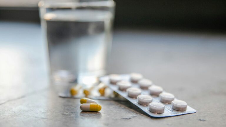 Blister pack of PEP tablets beside a glass of water, ready for a daily dose
