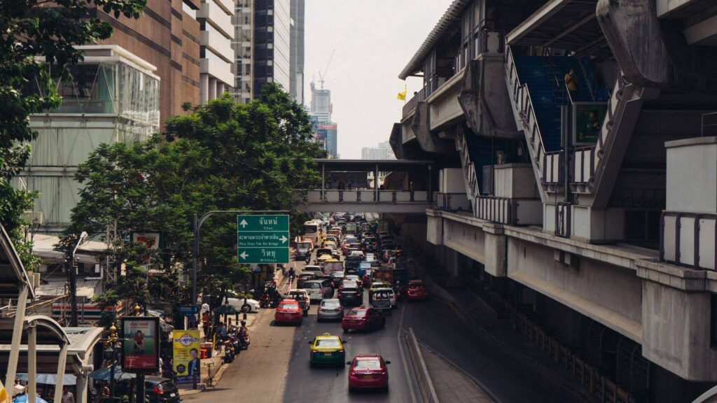 Busy Sukhumvit Road in central Bangkok at night with shops and street lights