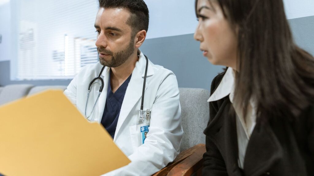 Doctor talking with a patient at a clinic desk about daily and on-demand PrEP options