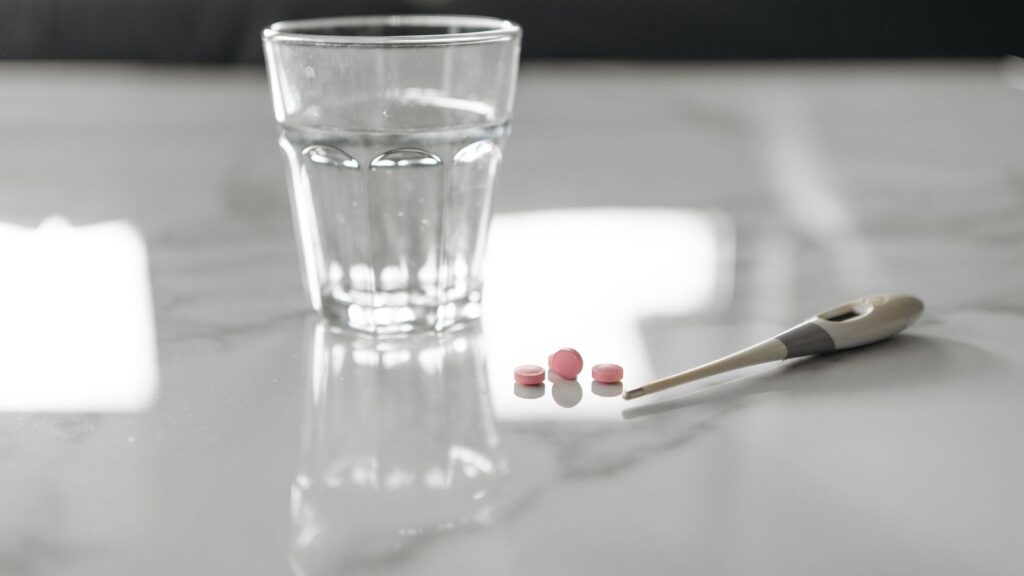 Glass of water and white tablets on a kitchen table in the morning, ready for a daily PrEP dose