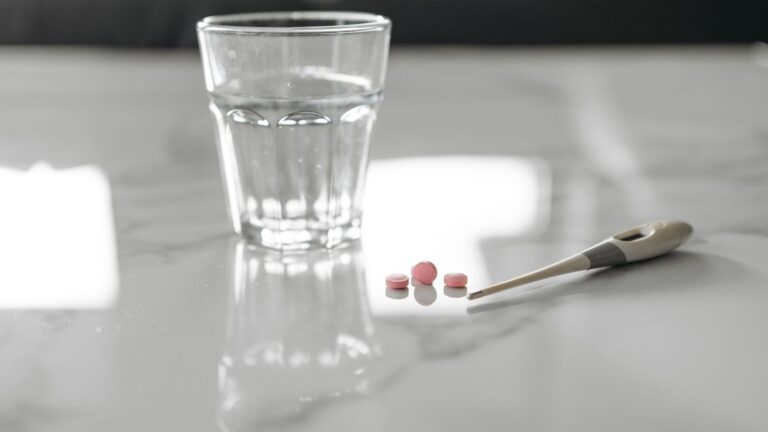 Glass of water and white tablets on a kitchen table in the morning, ready for a daily PrEP dose