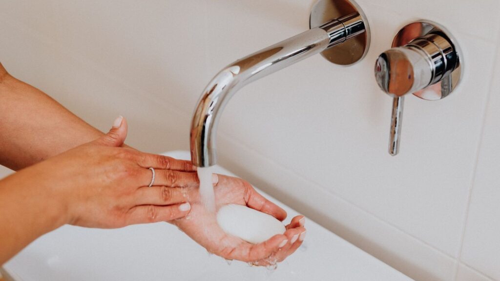 Hands washed with soap under running water, the first step after a needle-stick injury