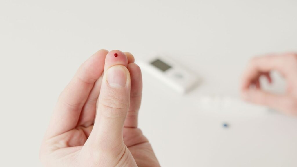 Healthcare worker holding a rapid finger-prick blood test cassette