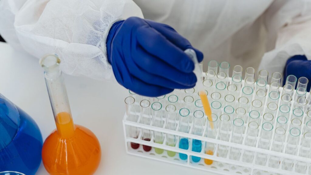 Laboratory scientist using a pipette with sample tubes, as used for follow-up HIV tests