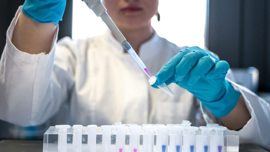 Laboratory technician handling sample tubes for confirmatory HIV testing