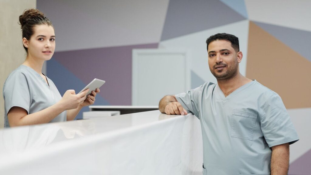 Patient speaking with a receptionist at a clinic desk to ask about a PEP assessment