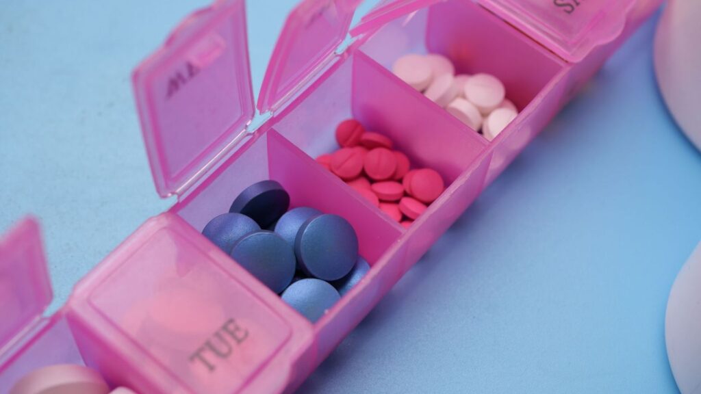 Weekly pill organiser holding daily tablets, a reminder to take PEP every day for 28 days