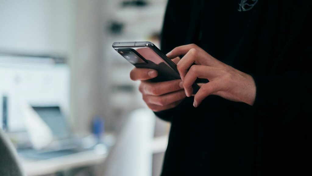 Person messaging a clinic on a smartphone to book a follow-up HIV test