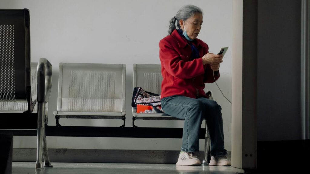 Person waiting calmly with a phone while a rapid HIV test result is prepared