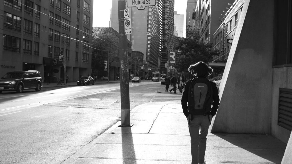 Person walking outdoors on a sunny day after a follow-up test