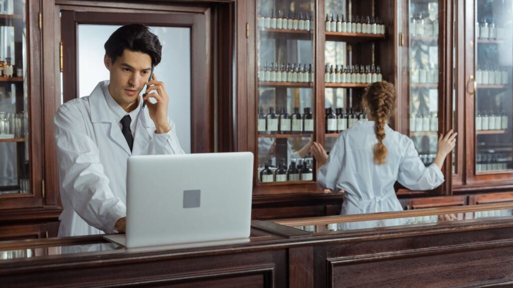 Pharmacist talking with a customer at a pharmacy counter about buying a registered test kit
