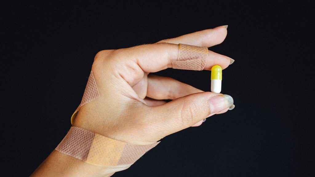 Plaster being put on a fingertip after cleaning a small puncture wound
