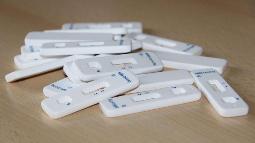 Rapid HIV test cassette on a clinic table, used for baseline and follow-up testing
