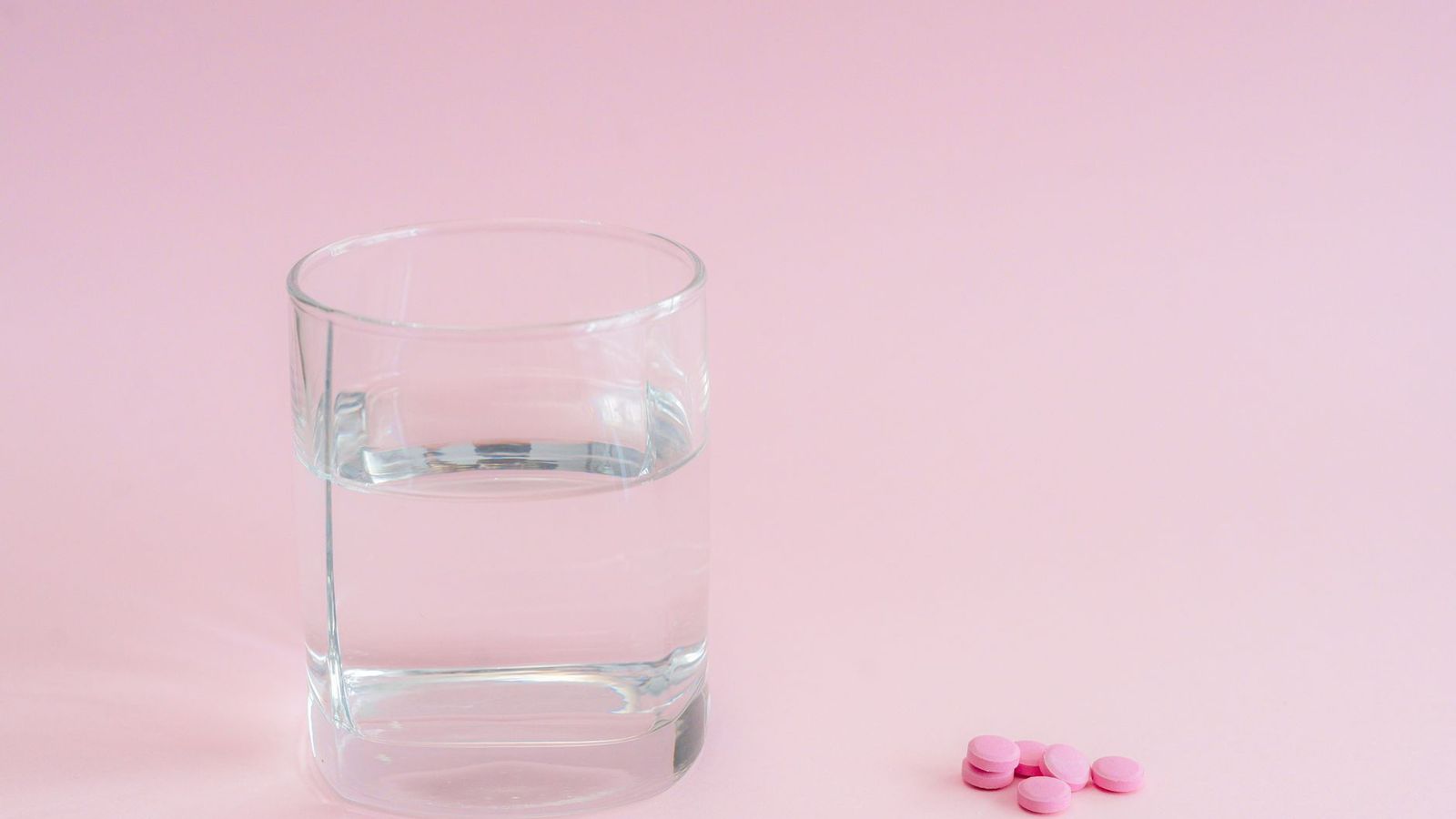 Tablets beside a glass of water and a light breakfast, a reminder to take PEP with food at the same time each day