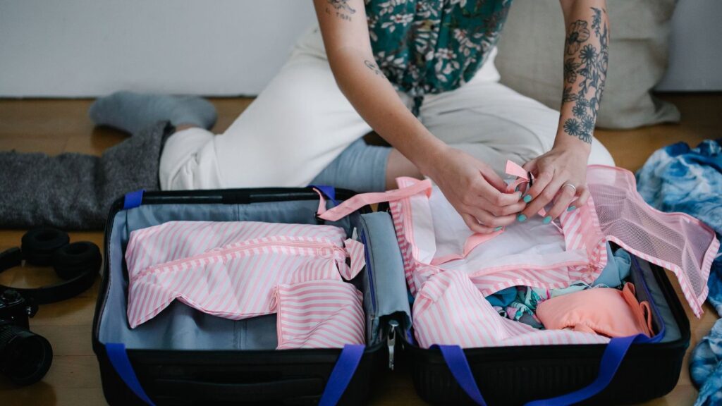 Toiletry bag being packed into a suitcase, a reminder to carry PrEP tablets when travelling