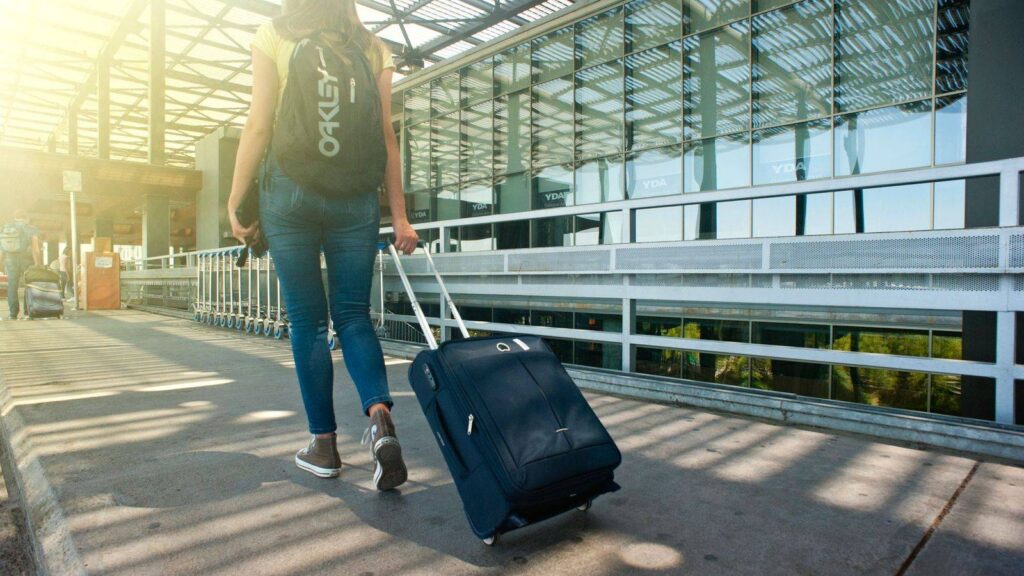 Traveller with a suitcase walking through an airport departure hall
