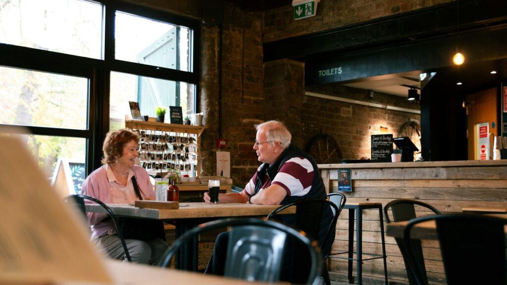 Two adults talking calmly at a cafe table about HIV status and testing