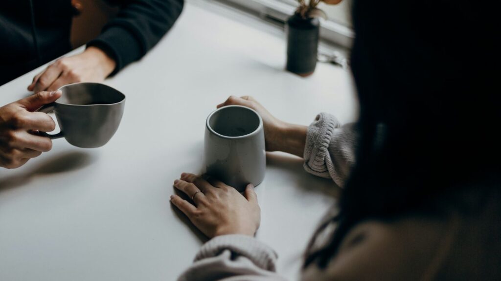 Two friends talking over coffee, getting support while waiting for HIV test results