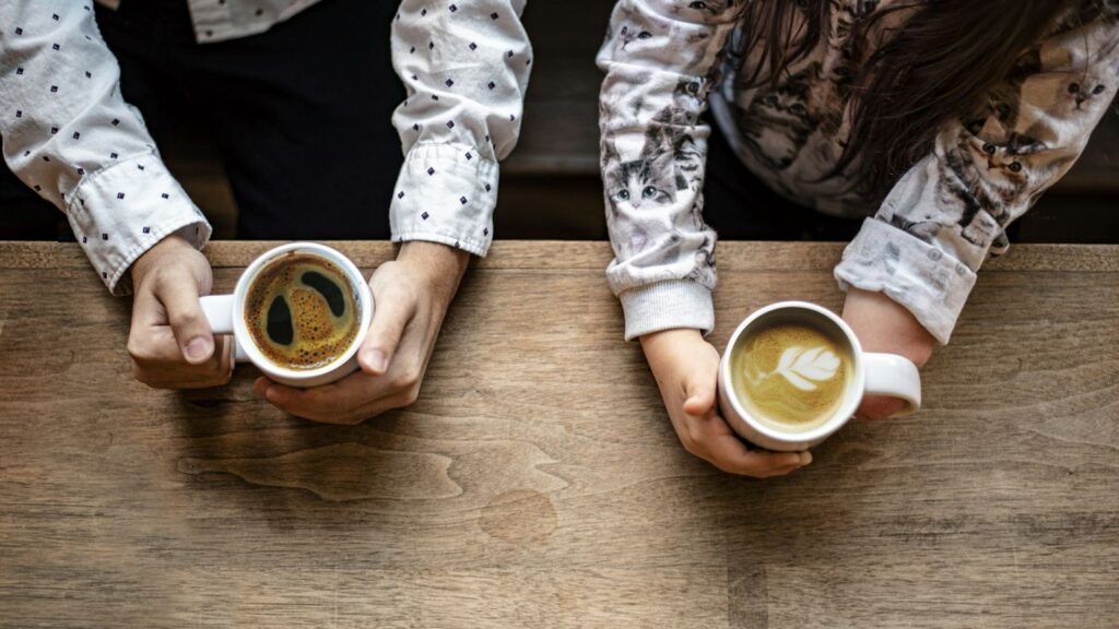 Two people talking over coffee, as open conversations about HIV status and treatment become easier