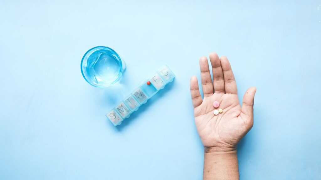 Weekly pill organiser and a glass of water, a reminder that PEP is a 28-day course