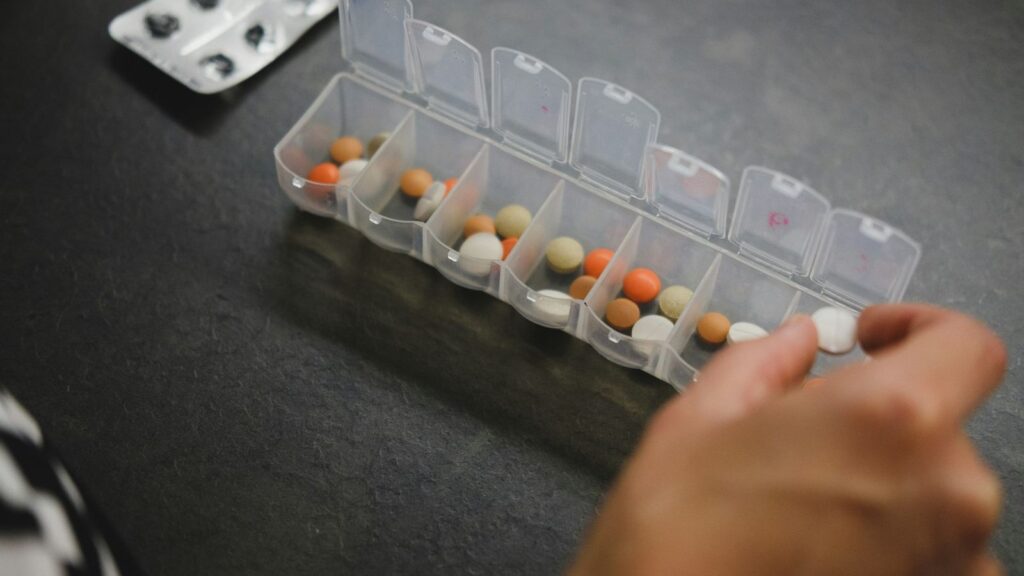 Weekly pill organiser holding daily tablets, a simple way to keep track of a 28-day PEP course