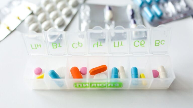 Weekly pill organiser with white tablets on a table, representing a planned on-demand PrEP schedule