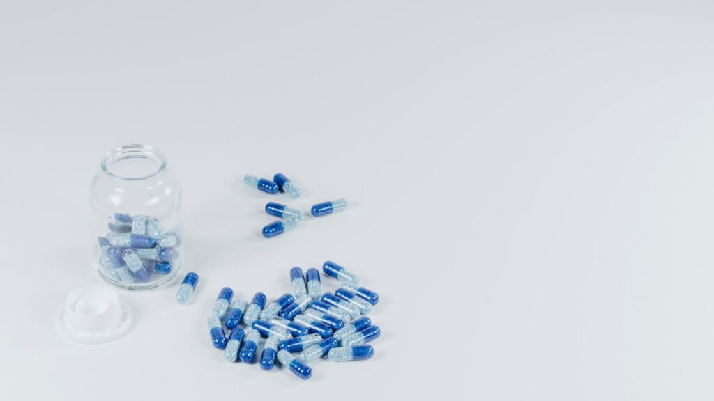 Capsules beside an open pill bottle, representing the first days of taking daily PrEP