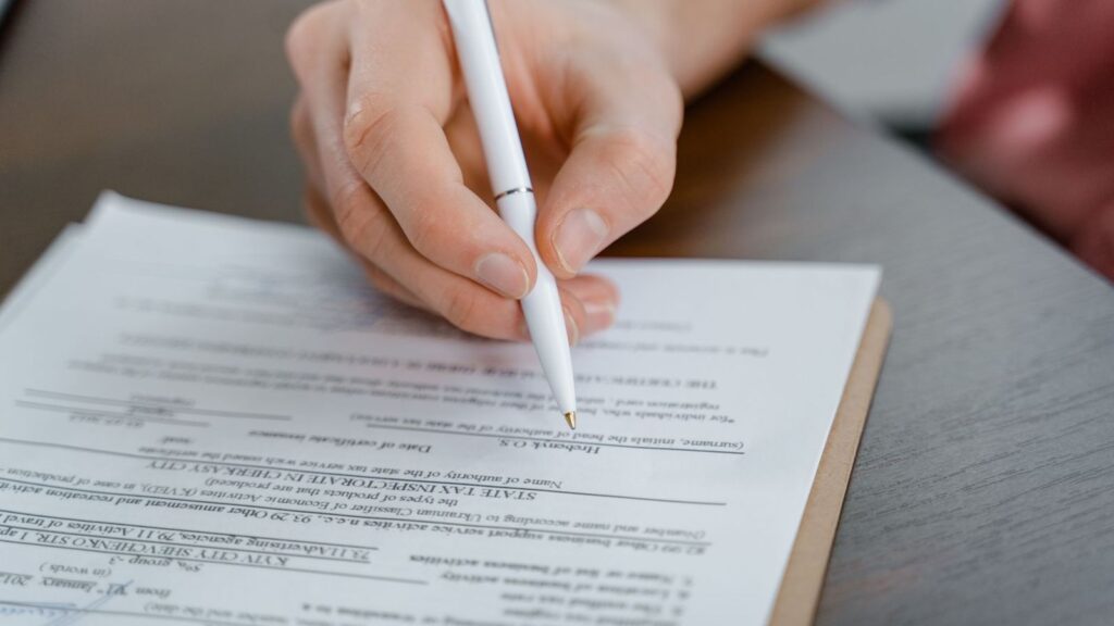 Worker completing an incident report form at a desk after a sharps injury