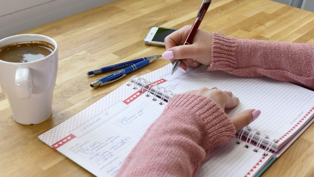 Writing follow-up test dates in a paper planner after an HIV test